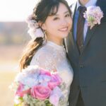新郎の胸に顔を寄せて微笑む花束を手に持つ新婦